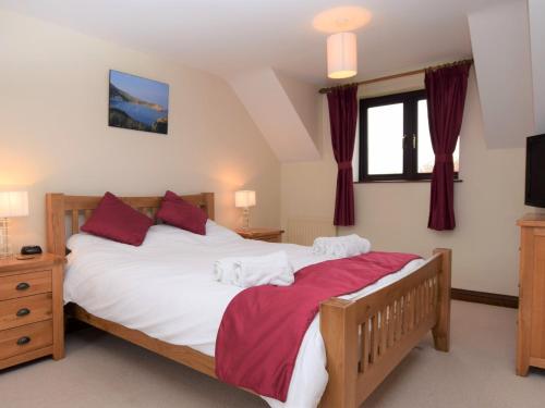a bedroom with a large white bed with red pillows at 3 Bed in East Stoke DC106 in East Stoke