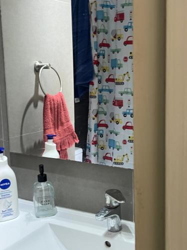 espejo de baño con lavabo y cortina de ducha en Resort Laguna del mar en La Serena