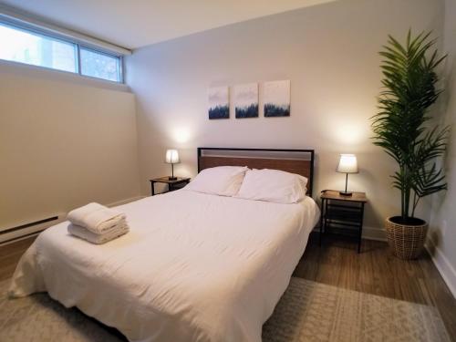 1 dormitorio con 1 cama blanca grande y 2 lámparas en Modern and spacious 2 bedroom in Montreal, en Montreal