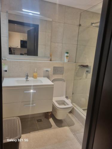 y baño con lavabo, aseo y espejo. en M.R APARTMENTS, en Accra