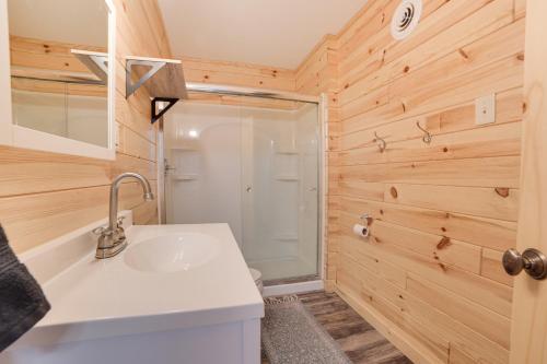 uma casa de banho com um lavatório e um chuveiro em Scenic Evans Hideaway Steps to Lake Huron! em Oscoda