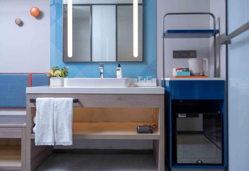 a bathroom with a sink and a mirror at Holiday Inn Express Shanghai Hongqiao NECC by IHG in Shanghai