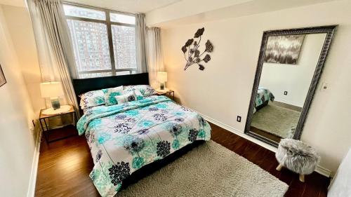 - une chambre avec un lit et un grand miroir dans l'établissement Modern & Cozy 1BR w/ parking by Square One, à Mississauga