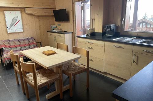 a kitchen with a table and chairs and a sink at Lovely family nest in Courchevel in Courchevel