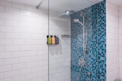 唐克斯特的住宿－唐克斯特假日酒店，一间墙上装有瓶子的淋浴的浴室