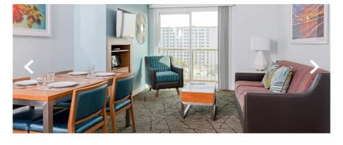 a living room with a table and chairs and a room with a couch at Worldmark in Anaheim