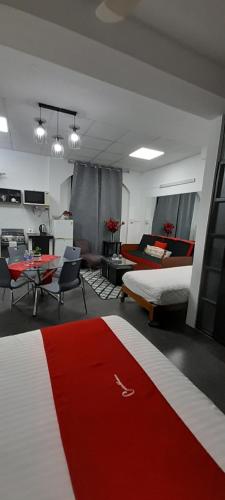 a room with a red and white bed and a table at Casablanca 4 in Tacna