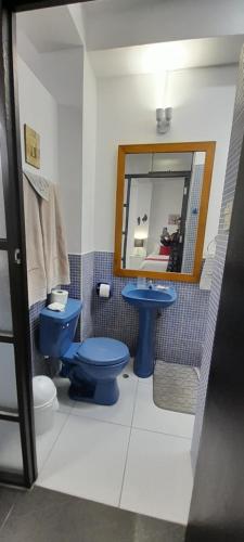 a bathroom with a blue toilet and a mirror at Casablanca 4 in Tacna