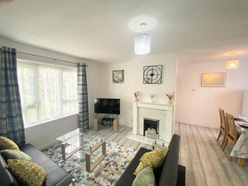 a living room with a fireplace and a tv at Comfy & Affordable home - Sleeps 7, free off-street parking near City centre, Cadbury World & Cannon Hill Park in Kings Norton