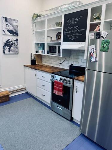 a kitchen with a stainless steel stove and refrigerator at Pet-Friendly Space #3 at Doggy Digs, King Bed and Office in Halifax