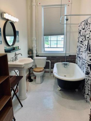 a bathroom with a tub and a toilet and a sink at Pet-Friendly Space #3 at Doggy Digs, King Bed and Office in Halifax