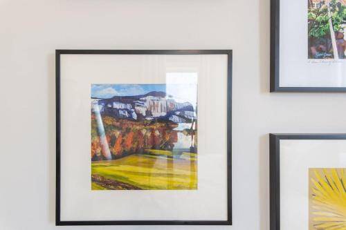 a group of framed paintings hanging on a wall at BikeslParkPasslPizzaOvenlSnoConelYouTubeTVlEV in Greenville