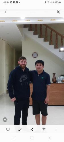 two men standing next to each other in a room at VIỆT HƯNG HÀ GIANG Hostel motorbikes for rental in Ha Giang