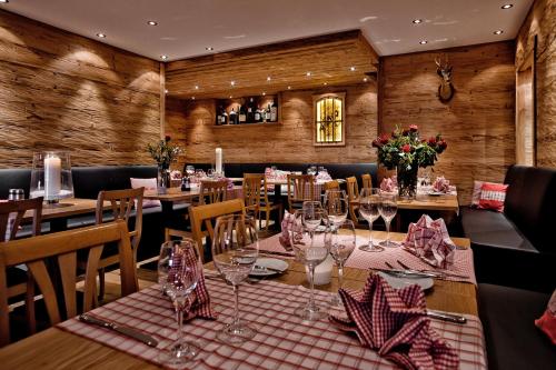a restaurant with wooden walls and tables with wine glasses at Arosa Vetter Hotel in Arosa