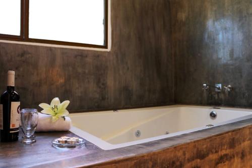a bath tub sitting on a counter with a bottle of wine at Hotel Bugamvillas Tapalpa extensión in Tapalpa