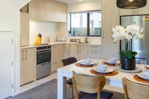a kitchen with a white table and chairs and a table and chairsktop at 3 Bedroom Hagley Park Paradise in Christchurch
