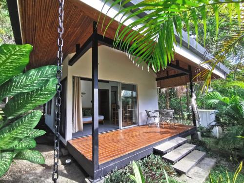 a house with a wooden porch with a swing at Armadillo Eco Bungalows - Santa Teresa in Santa Teresa Beach