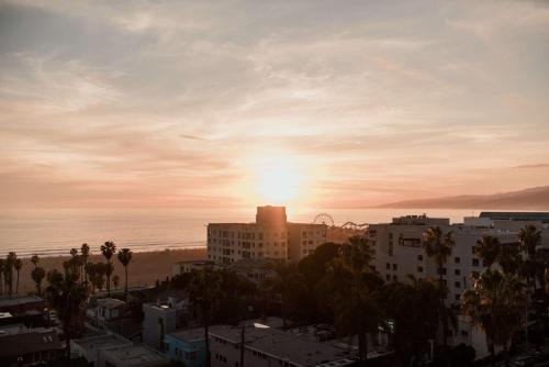 a sunset over a city with buildings and the ocean at Viceroy Santa Monica in Los Angeles