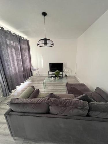 a living room with a large brown couch in a room at Centrally located stylish family suit Next to the train station in London