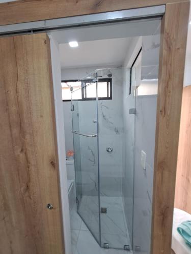 a glass shower in a bathroom with a window at Ultra mini suite privada con baño in Guayaquil