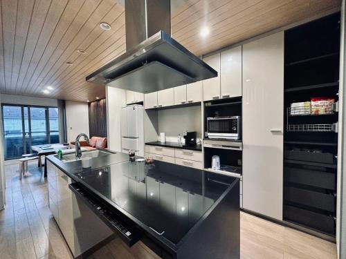 a large kitchen with a large black counter top at Zut Shinjuku House-SJ0415 in Tokyo