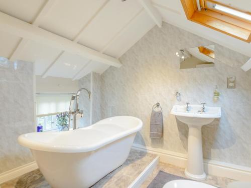 a bathroom with a white tub and a sink at 2 Bed in Rothbury 74811 in Rothbury