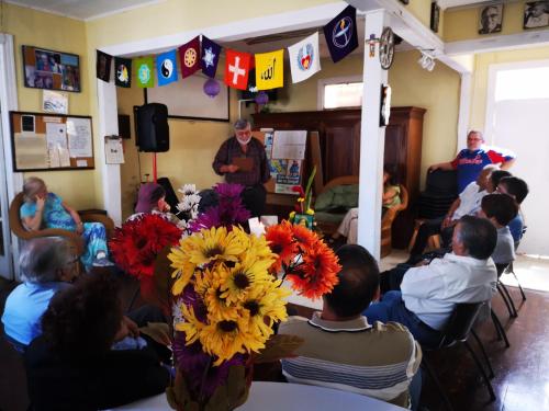 a group of people sitting in a room with a vase of flowers at Hostel Casa Ridgway in San José