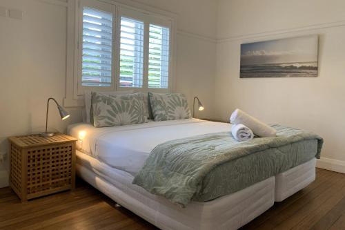 um quarto com uma grande cama branca e 2 candeeiros em Byron Palms Guesthouse & Spa - Adults Only em Byron Bay