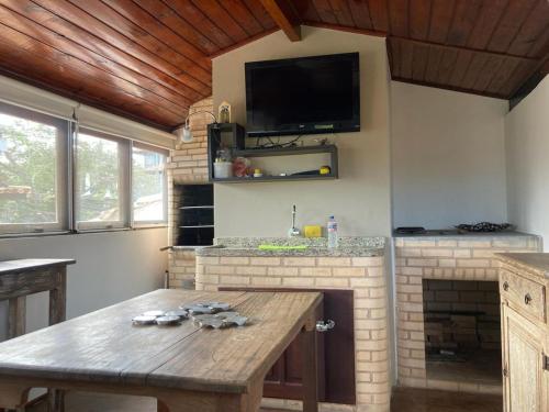 una cucina con tavolo in legno e TV a parete di Geribá - A casa mais Buziana e charmosa de Búzios a Búzios