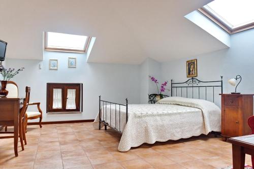 a bedroom with a bed and a desk and windows at Casa Vacanze Il Cenito in Castellabate