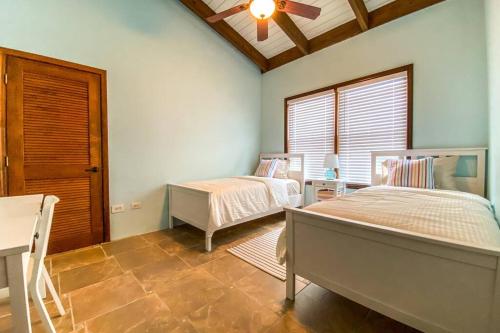 a bedroom with two beds and a ceiling fan at Private Oasis with Incredible Views in St Thomas