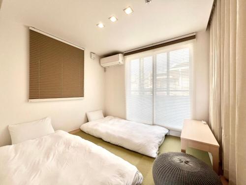 a bedroom with two beds and a window at Zut Shinjuku House-SJ0415 in Tokyo