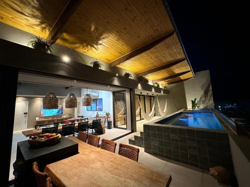 聖米格爾－杜斯米拉格里斯的住宿－Cobertura Milagres do Chef，客厅设有桌子和游泳池
