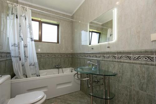 a bathroom with a sink and a toilet and a tub at Villa D'amore Montenegro in Donji Morinj