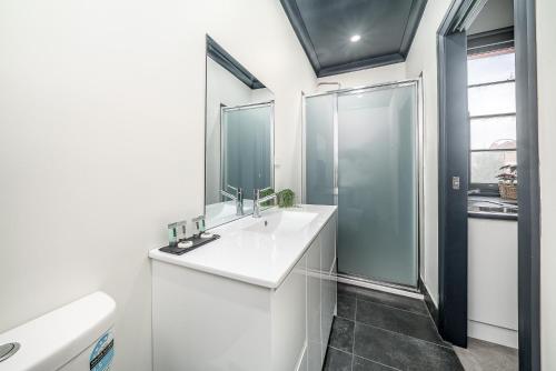 biała łazienka z umywalką i prysznicem w obiekcie Romano's Hotel & Suites Wagga Wagga w mieście Wagga Wagga