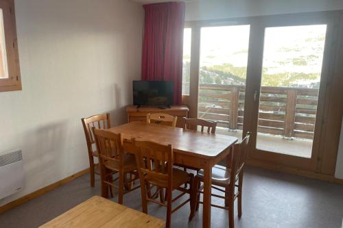 une salle à manger avec une table et des chaises et un balcon dans l'établissement Family cocoon at the foot of the slopes, à Saint-Étienne-en-Dévoluy