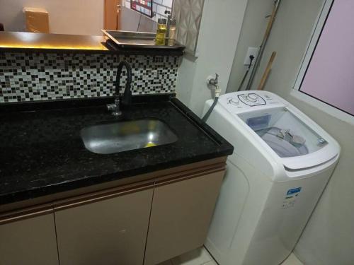 a bathroom with a sink and a trash can at Apartamento locação diária - residencial Belize in Botucatu