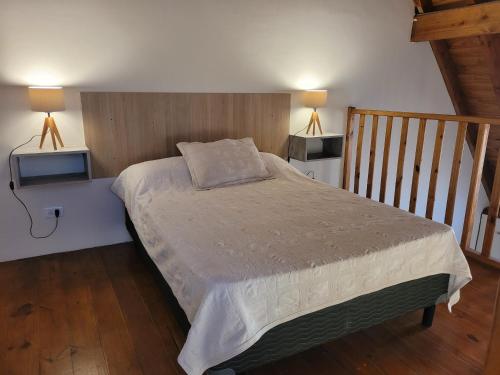a bedroom with a bed with two lights on the wall at KUPAL in Esquel