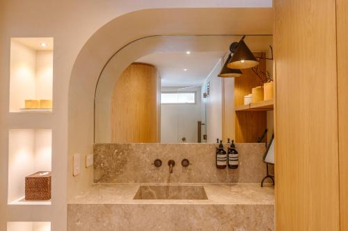 Netanya Noosa - Beachfront Resort في نوسا هيدز: حمام مع حوض ومرآة