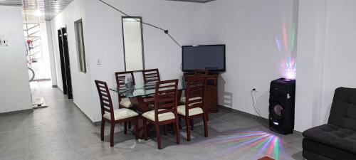 ein Esszimmer mit einem Glastisch und Stühlen in der Unterkunft Apartahotel San Isidro in Monguí
