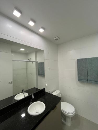 a bathroom with a toilet and a sink and a mirror at Studio cama King Size Westfit. in Mossoró