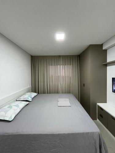 een slaapkamer met een groot bed en een televisie bij Studio cama King Size Westfit. in Mossoró