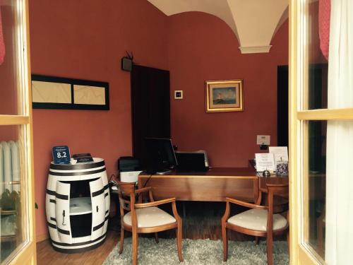 a waiting room with a table and chairs and a barrel at Albergo San Lorenzo in Alba