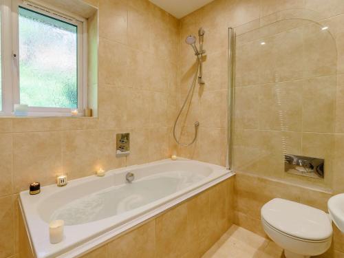 baño con bañera, aseo y ventana en 3 Bed in Keswick 90266, en Applethwaite