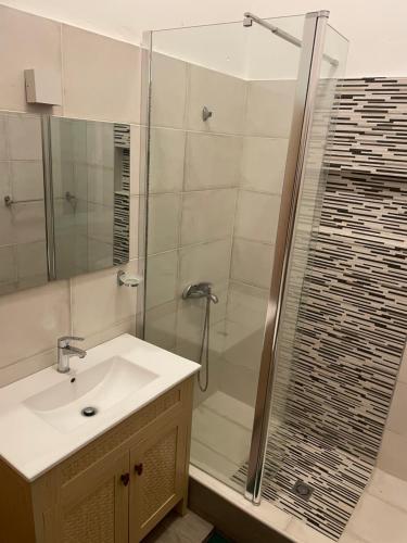 a bathroom with a sink and a shower at 1 habitation piscina boca chica in Cuevas