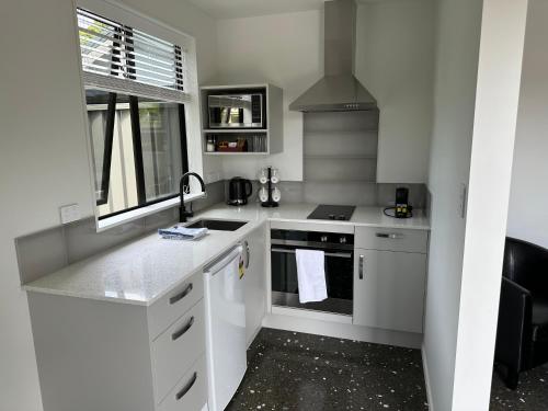 a white kitchen with a sink and a stove at Middle Park Motel in Blenheim