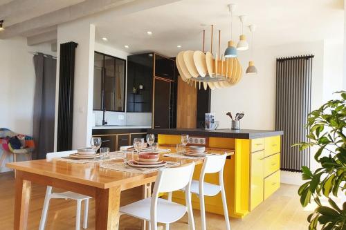- une cuisine avec une table en bois et des chaises blanches dans l'établissement Le Loft Perret - Vue Volcan et Centre Ville, au Havre