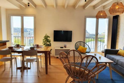 un salon avec une table, des chaises et un canapé dans l'établissement Le Loft Perret - Vue Volcan et Centre Ville, au Havre