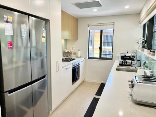 eine Küche mit einem Kühlschrank aus Edelstahl in der Unterkunft Waterfront Escape 2Bdr, Wavepool, Restaurants in Darwin