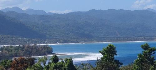 a view of a body of water with mountains at Tim Pappies Nature Lodge - Alex's Place in Port Antonio